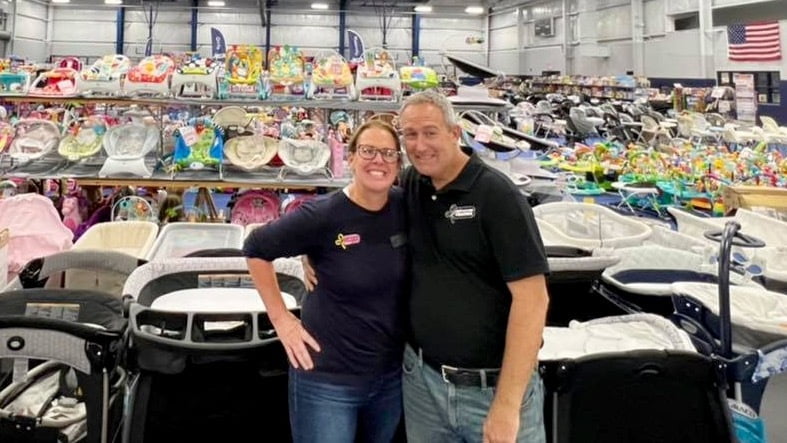 Owner of the JBF Gainesville JBF sale, Karen Miner and her husband smile on the sales floor.